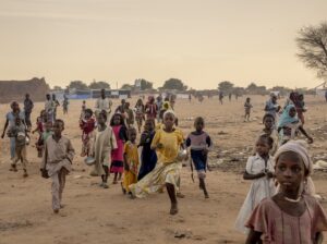 Adre, Chad - Displaced Sudanese children ran to try and get in line to receive food during an impromptu aid distribution on the outskirts of Adre refugee camp.